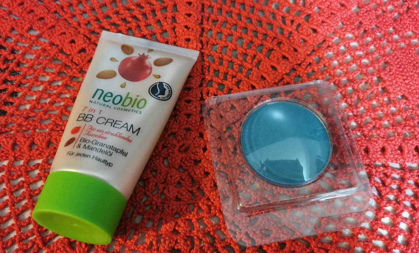 Trucco antietà: Neobio BB Cream 7 in 1 con estratti di melograno e mandorle per un incarnato uniforme e idratato, posizionata su un tovagliolo rosso ricamato, ideale per la cura quotidiana della pelle.