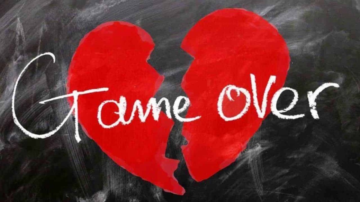 Cuore spezzato rosso con scritta "Game Over" in stile chalk su lavagna nera, tema triste e romantico per immagini legate a cuori spezzati e fine di un amore.
