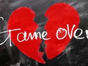 Cuore spezzato rosso con scritta "Game Over" in stile chalk su lavagna nera, tema triste e romantico per immagini legate a cuori spezzati e fine di un amore.