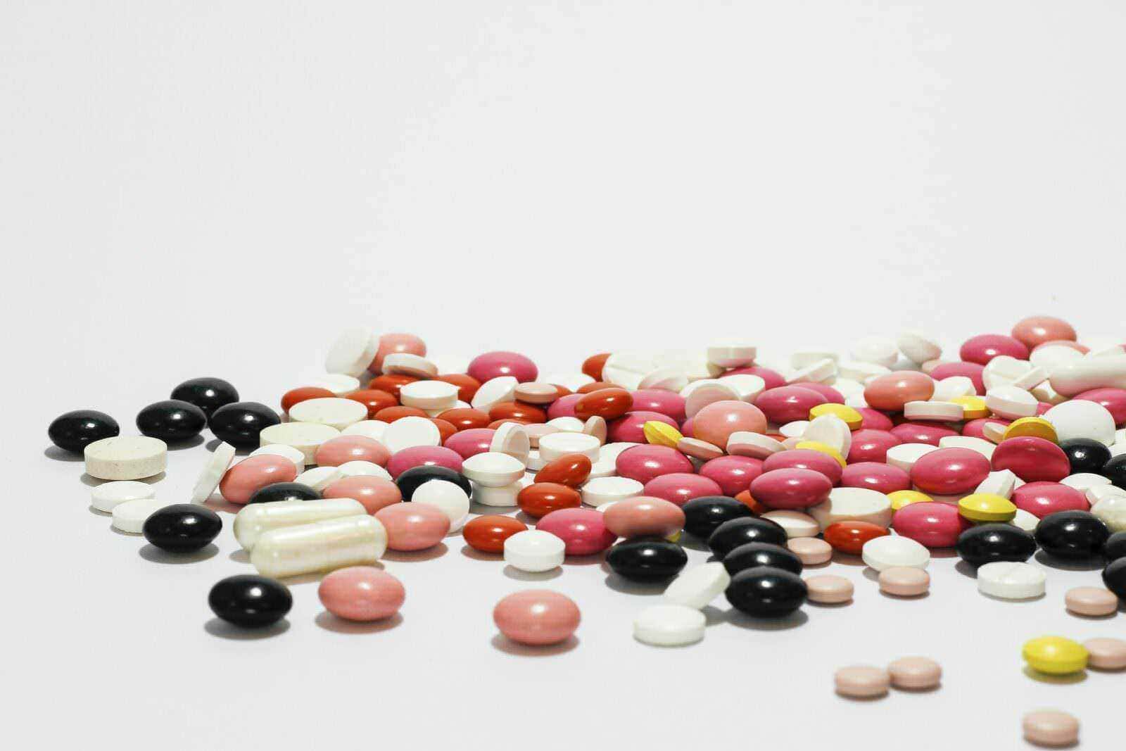 Come agiscono gli antibiotici sui batteri e sul covid 2 Come agiscono sui batteri: Pillole di diversi colori e forme sparse su uno sfondo bianco, rappresentano medicinali, integratori o farmaci. Ideale per articoli su salute, farmaci, medicina o benessere. Immagine simbolica di farmaceutica e trattamento medico.