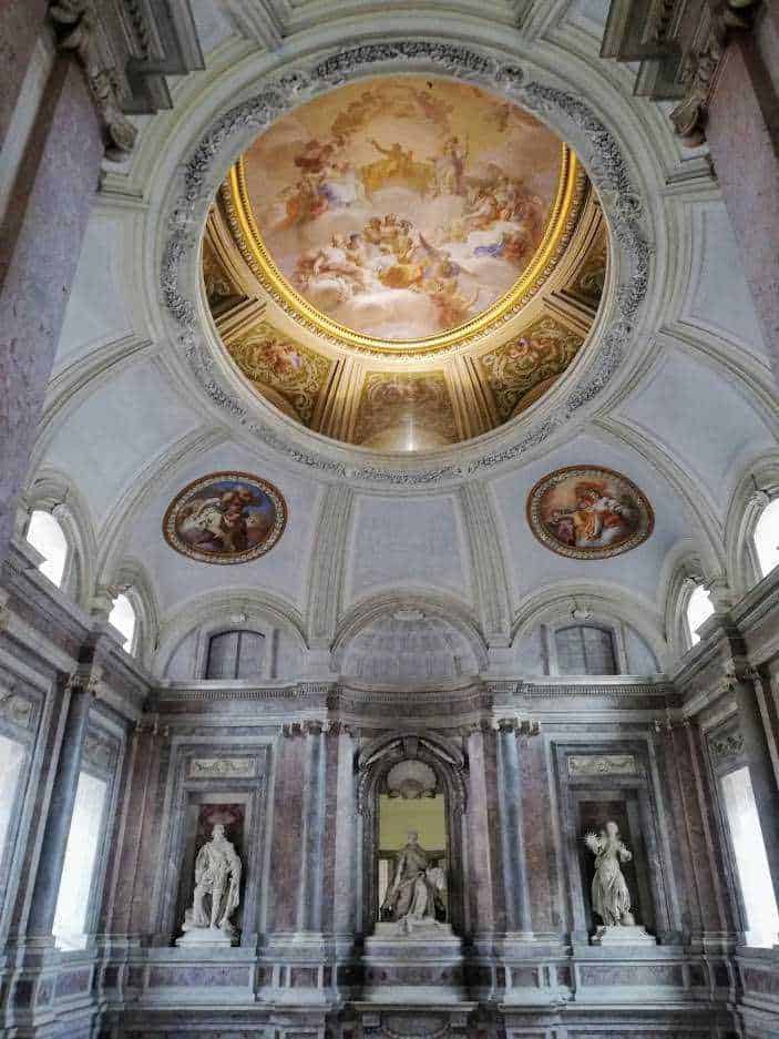 Arte barocca con soffitto affrescato e sculture in marmo, interno di una chiesa storica. Ricco di dettagli decorativi, colonne e dipinti sacri, rappresenta l'arte religiosa grandiosa e l'architettura elegante.