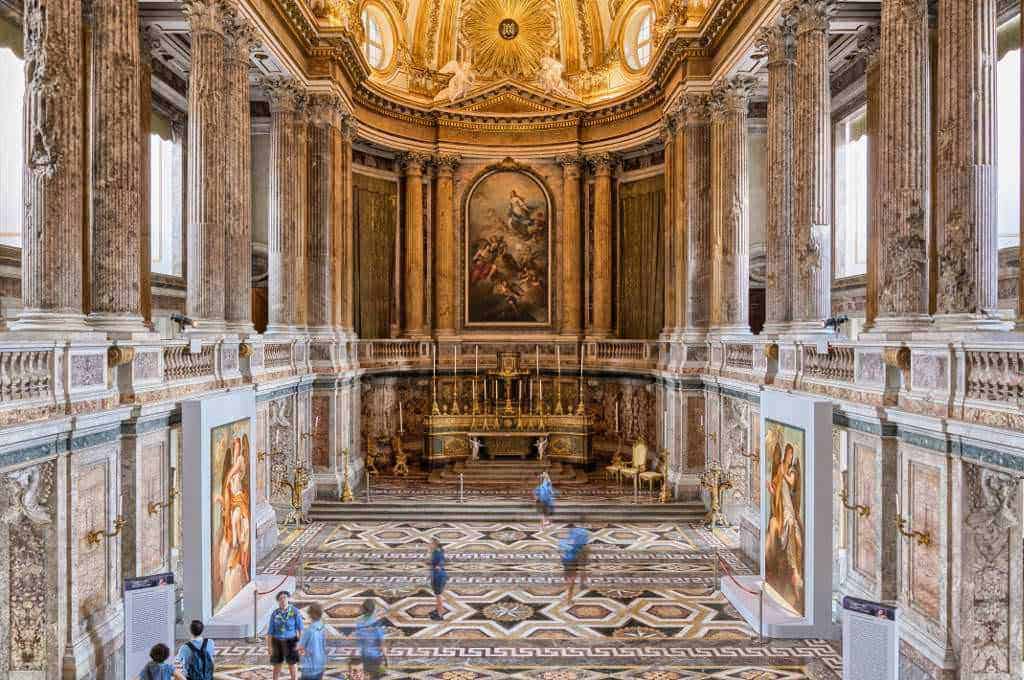 Opulenta sala barocca con affreschi dorati, colonne intricate e dettagli architettonici ricchi di storia in un museo di arte e cultura italiana.
