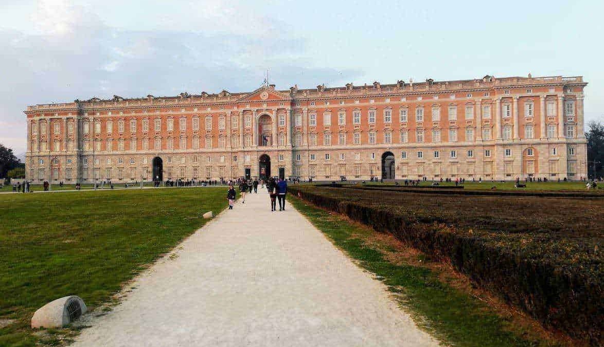 Immagine del Palazzo Reale di Torino visto da un percorso pedonale con persone che passeggiano nel parco.