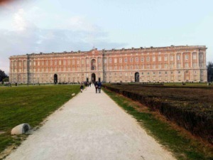 Immagine del Palazzo Reale di Torino visto da un percorso pedonale con persone che passeggiano nel parco.
