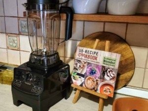 Vitamina, frullatore e ricettario su cucina casalinga per preparare smoothie e smoothie bowl sani e gustosi. Accessorio essenziale per chi ama frullare frutta e verdura per uno stile di vita salutare.