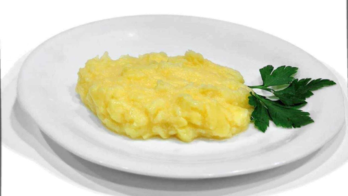 Pulitura delle patate lessate con prezzemolo su piatto bianco, ricetta semplice italiana.