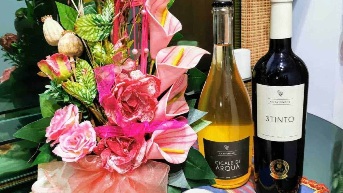Fiore artificiale colorato con bottiglie di vino, decorazione floreale elegante per occasioni speciali.