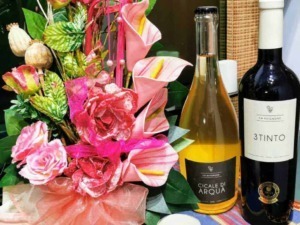 Fiore artificiale colorato con bottiglie di vino, decorazione floreale elegante per occasioni speciali.