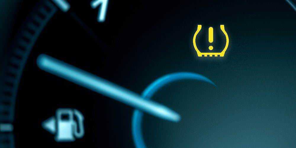 Pannello del cruscotto auto con indicatore di livello carburante e allarme di bassa benzina evidenziato in colore giallo.