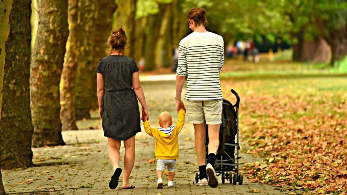 Famiglia che passeggia in parco autunnale, bambini e genitori, natura e relax, attività all'aperto, famiglie in vacanza, tempo di qualità insieme, foglie autunnali.