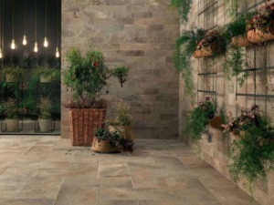 Fogli di piante verdi e fiori in fioriere di terracotta e insets di metallo su pareti di mattoni in stile moderno, ambiente lussuoso e accogliente, decorazione di interni elegante e naturale.