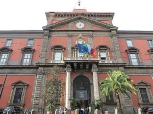 Palazzo storico con flags italiani ed europee, architettura classica, strada animata con persone, piante tropicali, atmosfera cittadina, centro città, edificio istituzionale, turismo a Palermo.