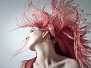 Capelli acconciatura rivoluzionaria colore rosa, immagine di una donna con capelli lunghi e mossi in movimento, stile moderno e creativo, perfetta per tema di moda, bellezza e tendenze.
