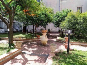 Elegante giardino con alberi da frutto, vasi decorativi e illuminazione esterna, ideale per relax e convivialità all'aperto. spazio verde curato e accogliente con piante e fiori.