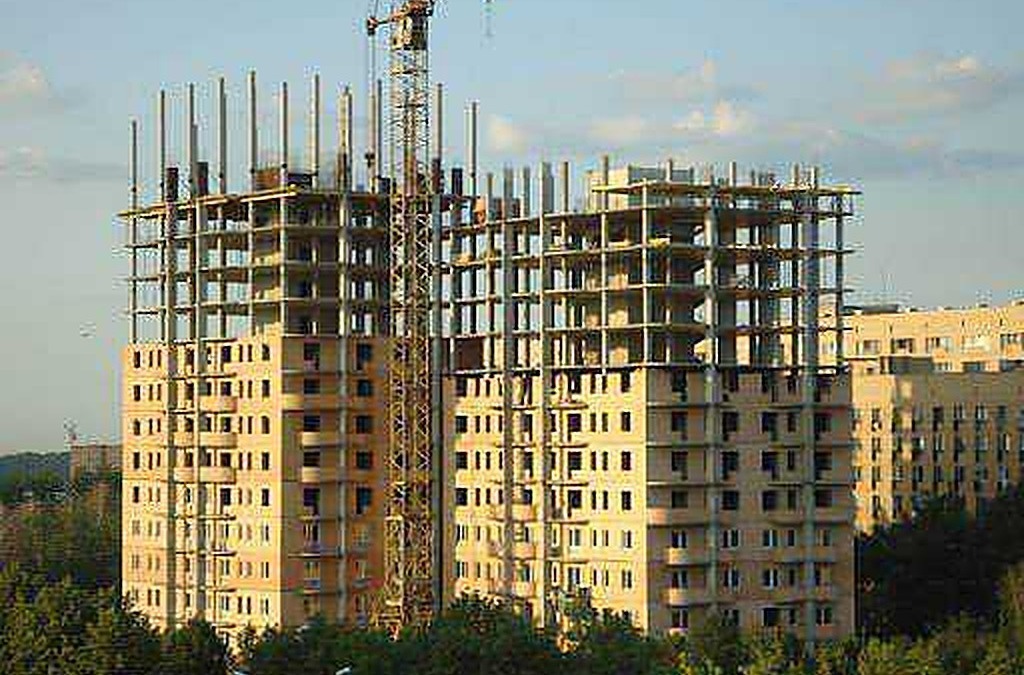 Cantiere edile con grù e costruzioni di edificio residenziale in corso di realizzazione, simbolo di sviluppo e crescita urbana.