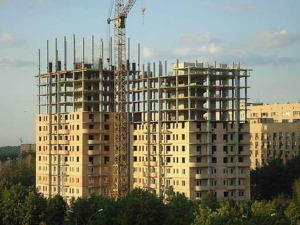 Cantiere edile con grù e costruzioni di edificio residenziale in corso di realizzazione, simbolo di sviluppo e crescita urbana.