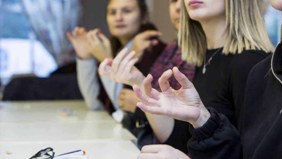 Conversazione di gruppo in ambiente professionale, donne che partecipano a un workshop o riunione, discutendo e condividendo idee su argomenti di lavoro.