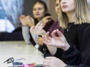 Conversazione di gruppo in ambiente professionale, donne che partecipano a un workshop o riunione, discutendo e condividendo idee su argomenti di lavoro.