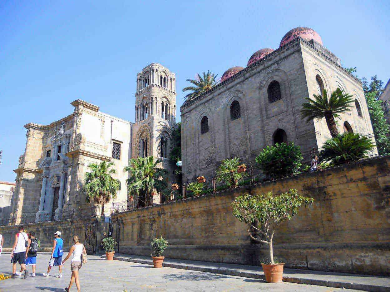25 luoghi da visitare a Palermo e dintorni in stile arabo normanno 7 Antico monastero in stile barocco con piante di palma e decorazioni architettoniche dettagliate. Un'icona storica e culturale, perfetta per apprezzare l'arte e la storia italiana