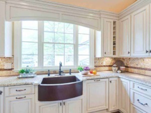 Lavandino da cucina in ceramica scura con finestra grande a giorno, mobili eleganti in stile classico e dettagli di marmo, decorazioni fresche con verdure e frutta, ambiente luminoso e accogliente.