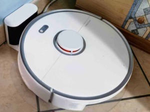 Robot aspirapolvere senza fili in azione su pavimento di ceramica in cucina, con superficie pulita e tecnologia avanzata per la casa intelligente.