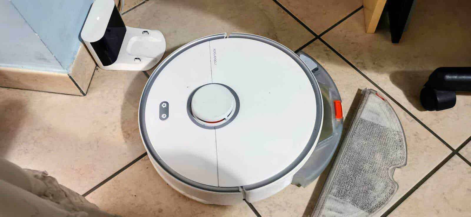 Robot aspirapolvere in funzione su pavimento in ceramica, dispositivo intelligente per la pulizia domestica, compatto e silenzioso.