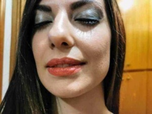 Bellissima donna con trucco elegante e trucco occhi smoky eye, capelli lisci e luminosi, in un ambiente caldo e accogliente.