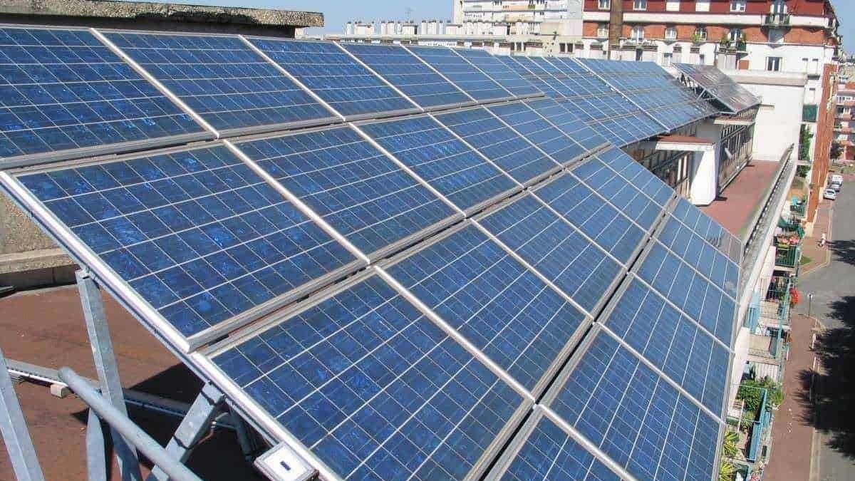 Pannelli solari fotovoltaici installati su tetto di edificio urbano, sfruttando energia rinnovabile per sostenibilità ed efficienza energetica.