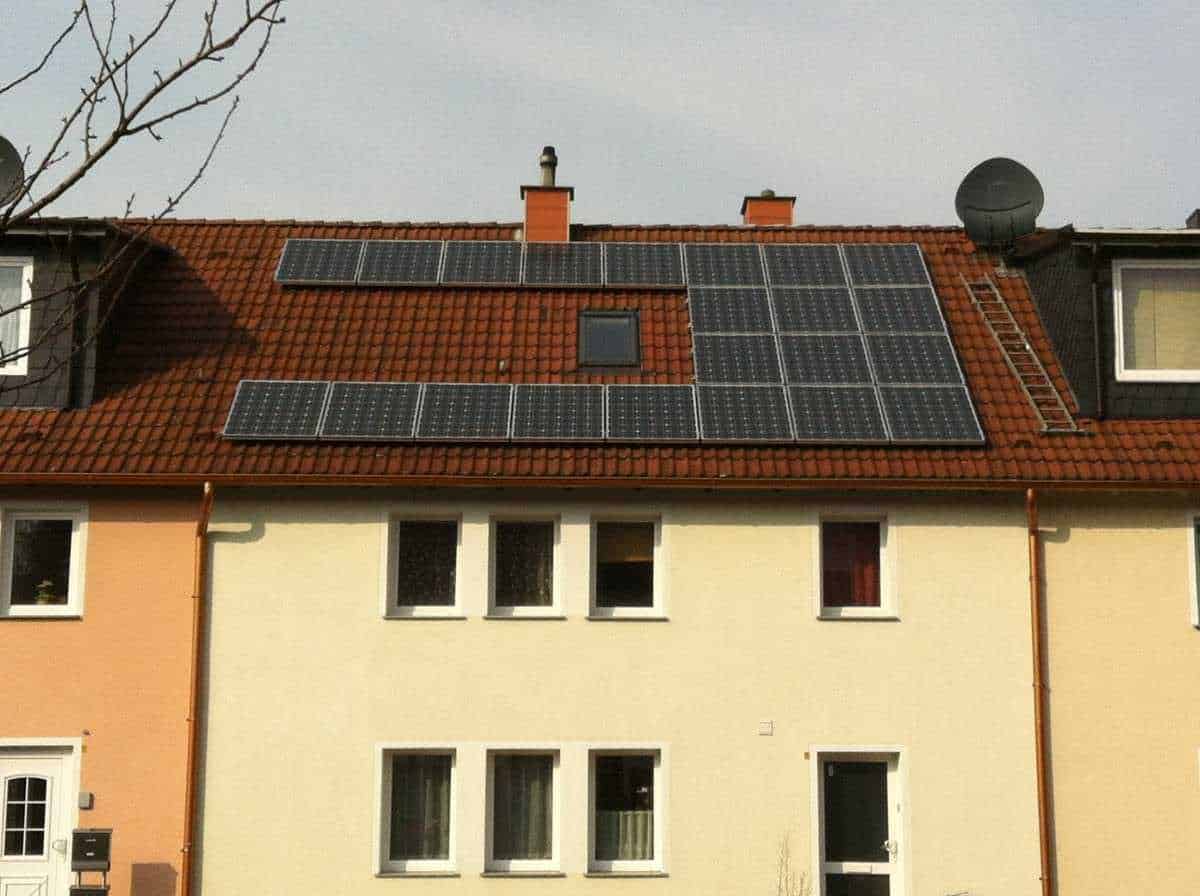 Pannelli solari installati sul tetto di una casa residenziale con tetto in tegole rosse, rappresentando un esempio di energia rinnovabile e sostenibilità ambientale.