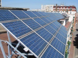 Pannelli solari fotovoltaici installati su tetto di edificio urbano, sfruttando energia rinnovabile per sostenibilità ed efficienza energetica.