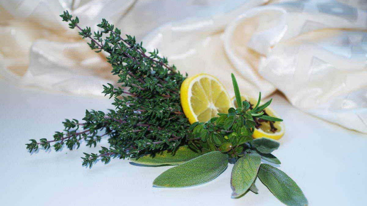Profumi aromatici con rosmarino, salvia e limone, piante officinali e agrumi per la cucina e la salute, ideali per decorazioni e rimedi naturali, su uno sfondo bianco elegante.