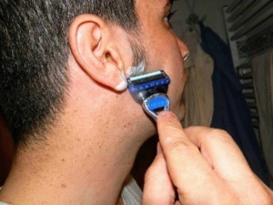 Rf: uomo che si rade con il rasoio elettrico sul viso.