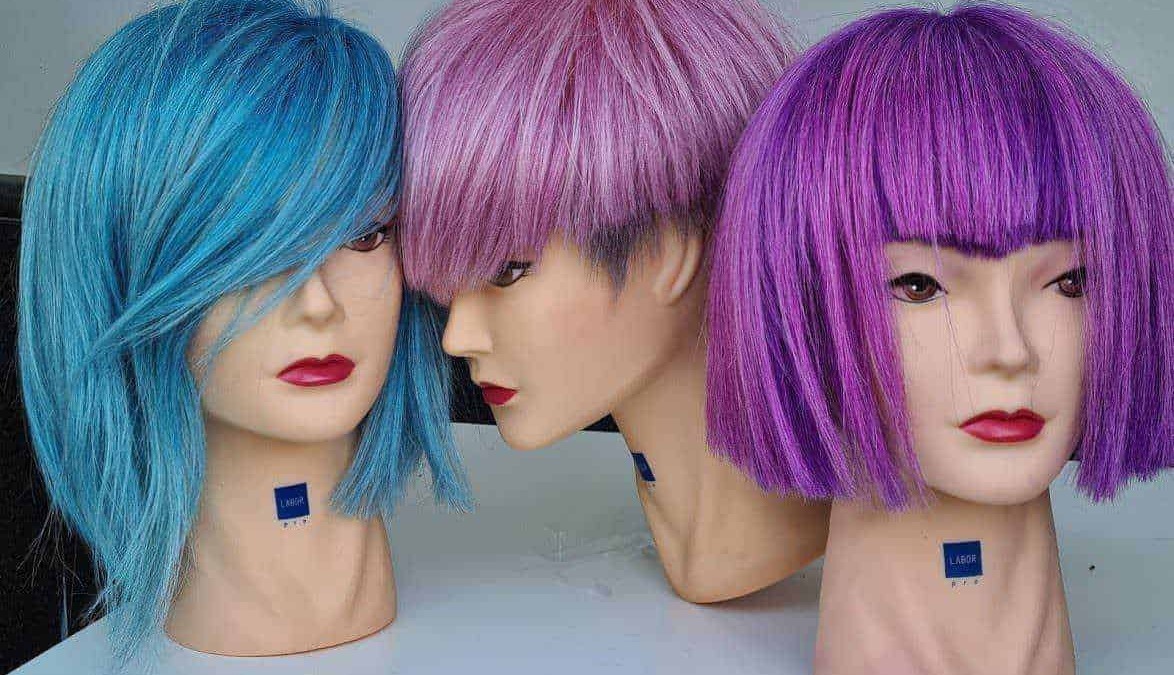 Lavaggi di parrucche colorate su manichini, mostrando diverse tonalità di blu, rosa e viola, ideali per look alla moda e personalizzazione dei capelli.
