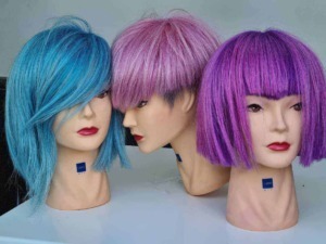 Lavaggi di parrucche colorate su manichini, mostrando diverse tonalità di blu, rosa e viola, ideali per look alla moda e personalizzazione dei capelli.