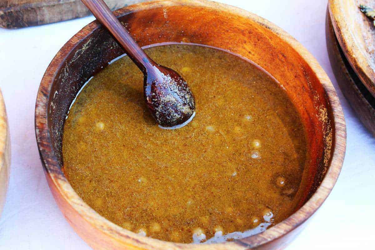 Salsa barbecue fatta in casa in una ciotola di legno, pronta per essere utilizzata come condimento per carne e piatti alla griglia. Perfetta per aggiungere sapore e gusto ai tuoi pasti all'aperto.