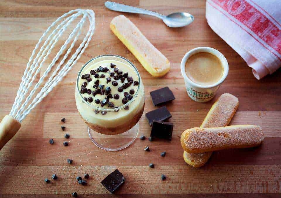 Barattolo di crema al cioccolato e caffè con biscotti sugli appunti, dolce colazione con cioccolato e caffè espresso.