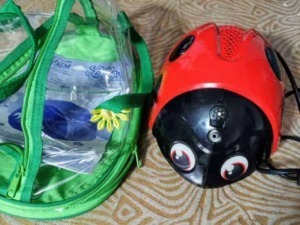 Casco da bici con occhi giocosi e sacca trasparente verde, ideale per protezione e sicurezza durante le attività all'aperto.