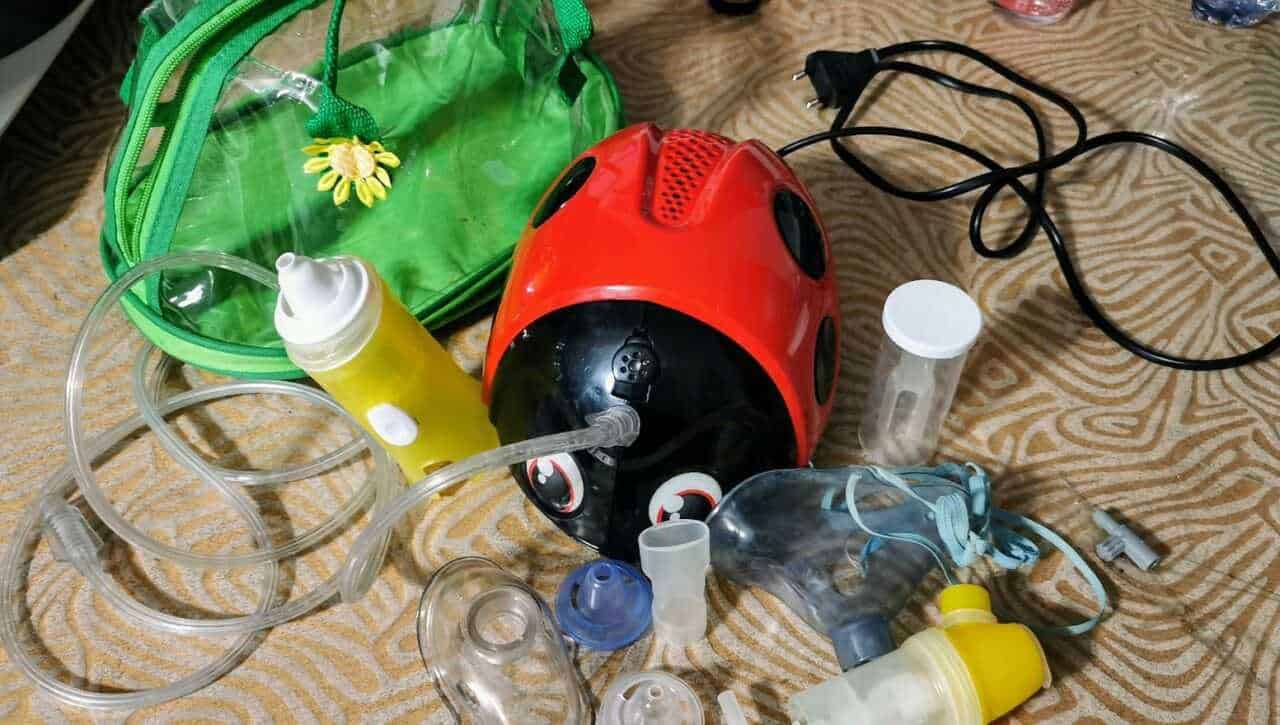 Bombole di ossigeno e attrezzature per terapia respiratoria con casco da nebbia, in ambiente domestico o di assistenza medica.