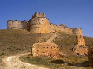 Castello medievale su collina, struttura storica, fortezza antica, architettura in pietra, monumento storico, viaggio culturale, storia antica, destinazione turistica.