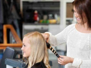 Acconciature donna in salone di bellezza, hairstylist che realizza un taglio di capelli alla cliente, ambiente professionale e accogliente, cura dei dettagli nella hairstyling.