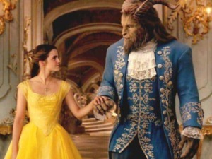 Elegante scena di un film con una donna in abito giallo e una creatura antropomorfa in abito blu, ambientata in un sontuoso salone dorato decorato in stile barocco, scena di fantasia e cinema storico.
