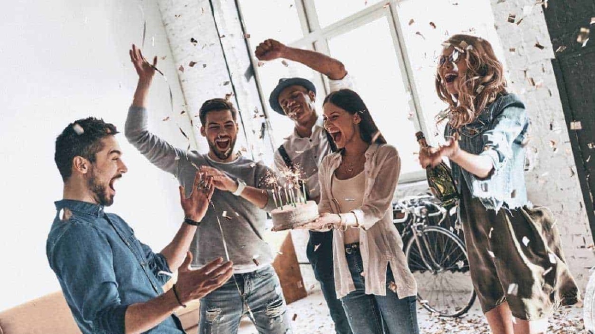 Momenti di festa tra amici con torta di compleanno e confetti in un ambiente luminoso e moderno, perfetto per condividere ricordi speciali e celebrare occasioni importanti.