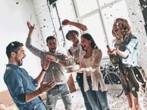 Momenti di festa tra amici con torta di compleanno e confetti in un ambiente luminoso e moderno, perfetto per condividere ricordi speciali e celebrare occasioni importanti.