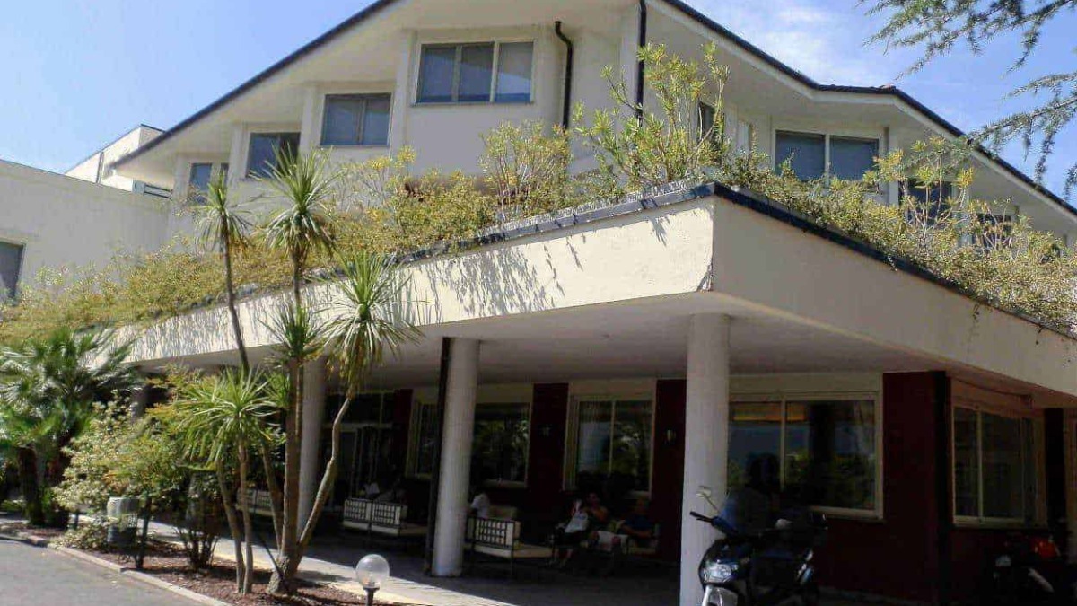 Appartamento moderno con balcone e giardino, stile architettonico contemporaneo, struttura residenziale, zona tranquilla, edificio di quattro piani, spazio esterno curato.