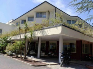 Appartamento moderno con balcone e giardino, stile architettonico contemporaneo, struttura residenziale, zona tranquilla, edificio di quattro piani, spazio esterno curato.
