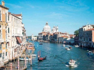 Venezia con gondole e barche sul Canal Grande, vista della Basilica della Salute e del panorama storico di Venezia, Italia, in una giornata soleggiata.