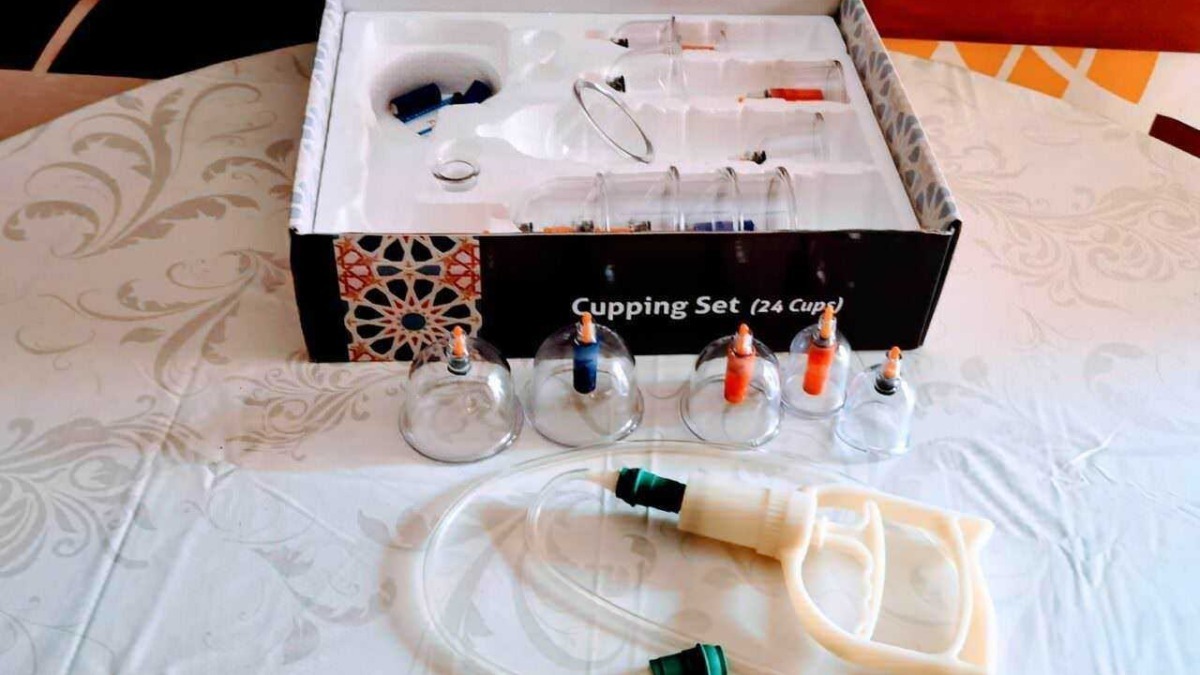 Set di bicchieri per il prelievo del sangue con pipette e siringa, contenuti in scatola per laboratorio medico, sul tavolo con tovaglia chiara.