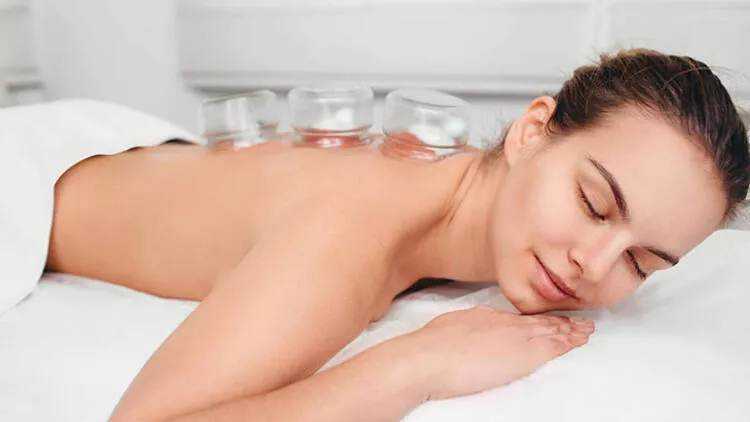 Relaxing massaggio terapico con coppette di vetro sulla schiena, immagine di benessere e trattamento relax presso Appunti Sul Blog.