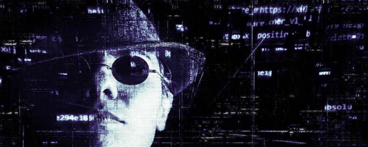Programmatore cyber sicurezza con occhiali da sole e cappello in ambientazione digitale con codici e schermate di computer, rappresenta la hacking etico e il cybersecurity.