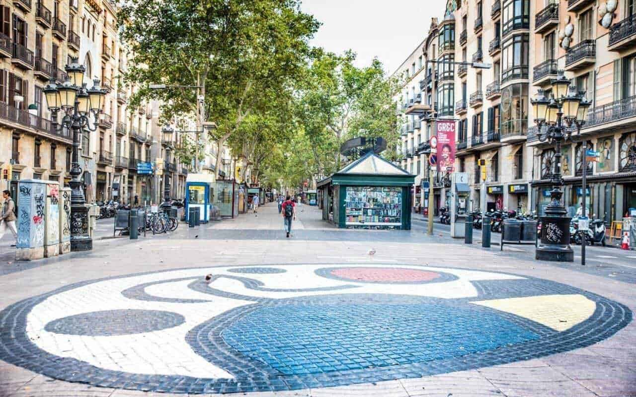 Top 11 siti da vedere: Colorato and vivace tratto di strada urbana con edifici storici, alberi, lampioni e panchine, perfetto per la vita cittadina e le passeggiate all'aperto. Atmosfera dinamica e accogliente dell'urbanistica di città storiche.